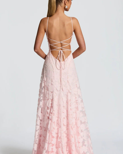 Back view of a women's pink floral jacquard maxi dress, highlighting the delicate lace-up back design and flowing skirt.