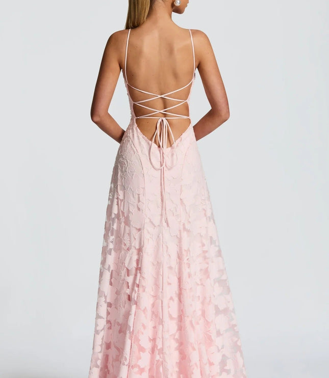 Back view of a women's pink floral jacquard maxi dress, highlighting the delicate lace-up back design and flowing skirt.