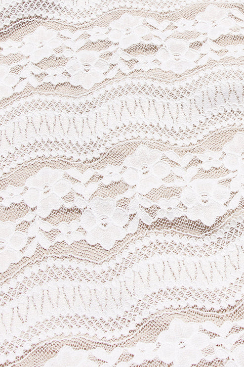 Close-up texture of the white floral lace fabric used for the off-shoulder long sleeve maxi dress.