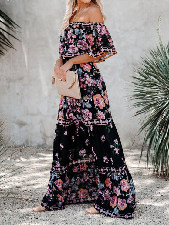 Side view of a black floral off-shoulder maxi dress, featuring pink and orange flowers and a tiered silhouette.