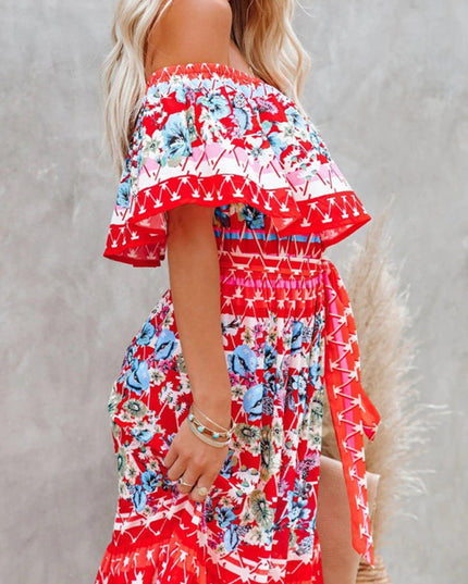 Side detail of a red floral off-shoulder maxi dress, showcasing the ruffled top, tie waist, and intricate patterns.