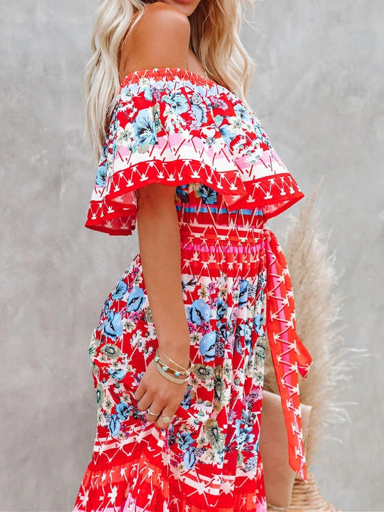 Side detail of a red floral off-shoulder maxi dress, showcasing the ruffled top, tie waist, and intricate patterns.