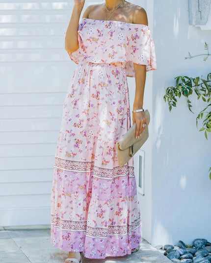 Light pink floral off-shoulder ruffled maxi dress with tiered skirt and delicate flower patterns, holding a clutch.