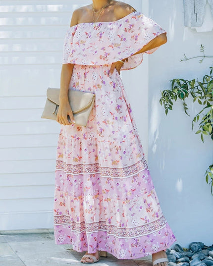 Side view of light pink floral off-shoulder ruffled maxi dress with a tiered skirt and a beige clutch.