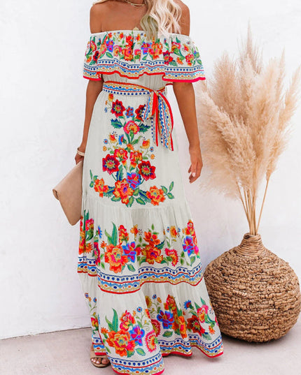 Front view of a women's white floral off-shoulder maxi dress, featuring a ruffled top and a tie-waist detail.