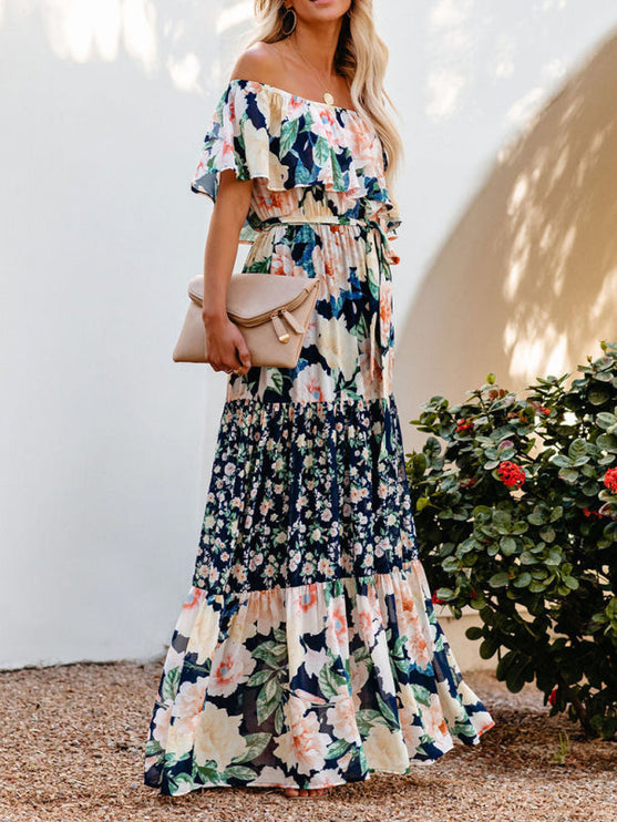 Front view of the women's off-shoulder ruffled floral maxi dress, featuring the navy blue, peach, and cream floral pattern.