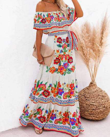 Side profile of a women's white off-shoulder floral maxi dress, showcasing the flowy skirt and colorful design.