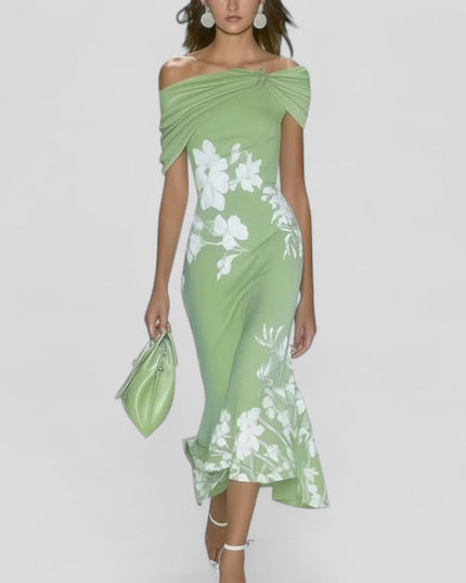 Light green off-shoulder midi dress with white floral print and trumpet hem, carried a matching handbag.
