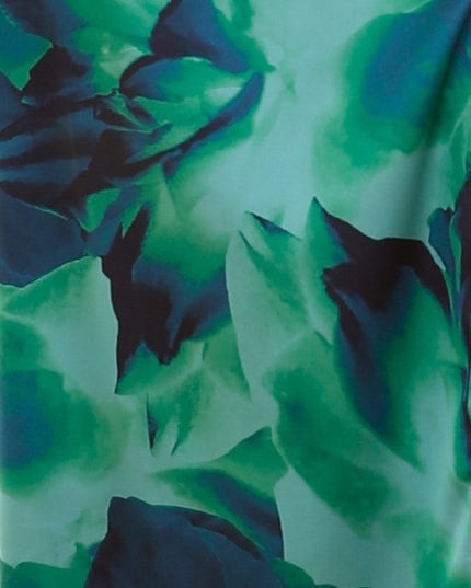 Close-up detail of the vibrant green and blue floral print fabric of the one-shoulder cut-out maxi dress.