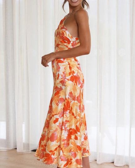 Side profile of a woman in an orange and white floral one-shoulder midi dress, showcasing the flowy fabric.