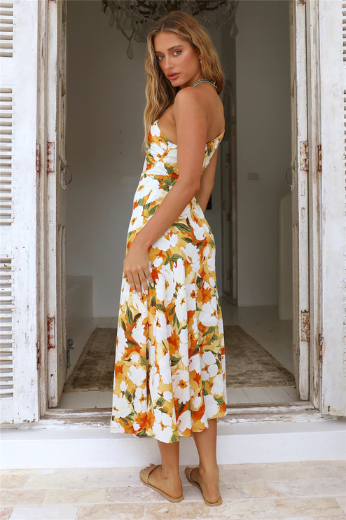 Side view of women's floral one-shoulder midi dress, white with orange flowers, showing mermaid hem.