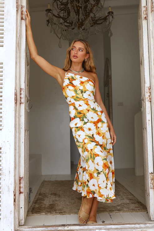 Full length view of women's floral one-shoulder midi dress, white with rich orange and green flower print.
