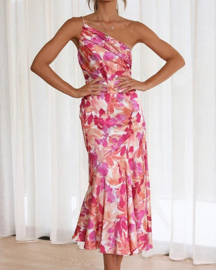 Women's floral one-shoulder midi dress in pink and fuchsia hues, ruched bust detail, elegant silhouette.