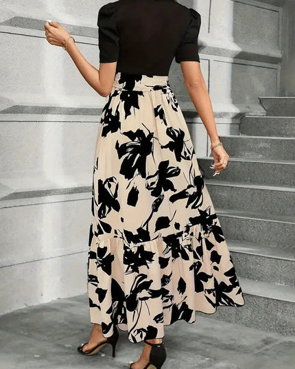 Back view of a women's high waist maxi dress with a black floral print on beige, showing the tiered skirt and short black sleeves.
