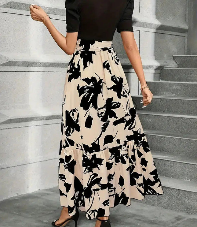 Back view of a women's high waist maxi dress with a black floral print on beige, showing the tiered skirt and short black sleeves.