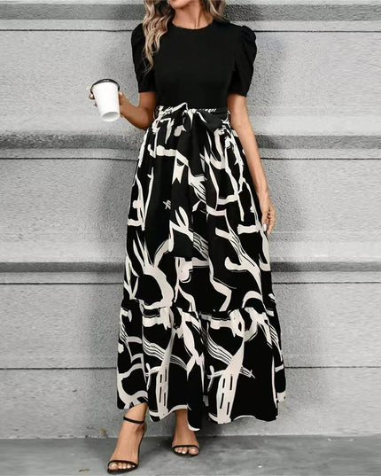 Women's black short sleeve top with a high waist maxi dress featuring a bold black and white abstract pattern, tied at the waist.