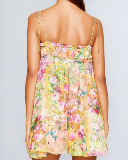 Back view of a women's floral print tie shoulder mini dress, showing the ruffled back and tie details.