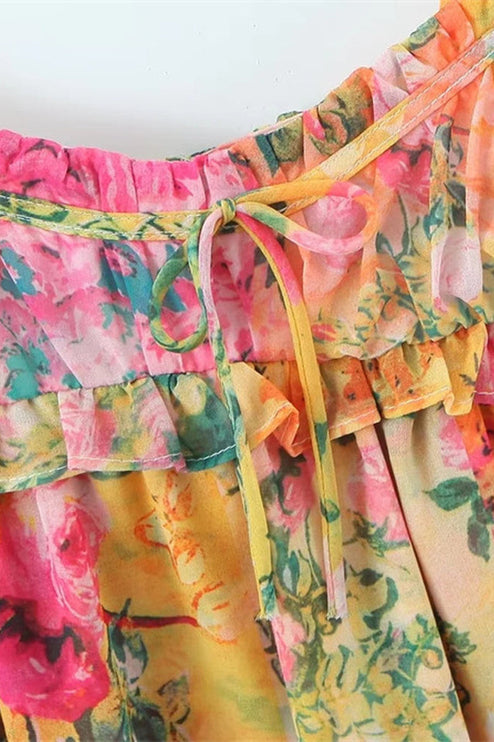 Close-up of the bodice of the floral print mini dress, highlighting the tie shoulder straps and ruffled neckline.