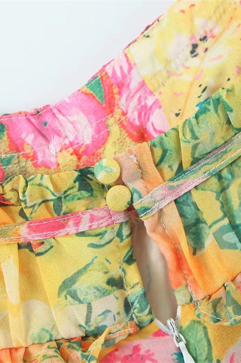Close-up of the back neckline of a women's floral print mini dress, showing two yellow button closures and ruffled trim.