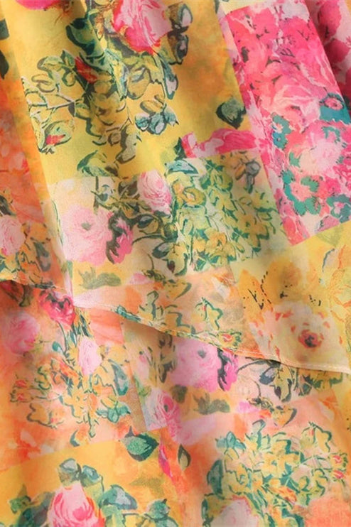 Detailed view of the layered ruffles and vibrant floral print on the tie shoulder mini dress fabric.