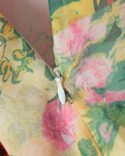 Detailed view of the side zipper closure on a women's floral print tie shoulder mini dress, featuring pink and green patterns.