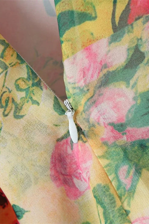 Detailed view of the side zipper closure on a women's floral print tie shoulder mini dress, featuring pink and green patterns.