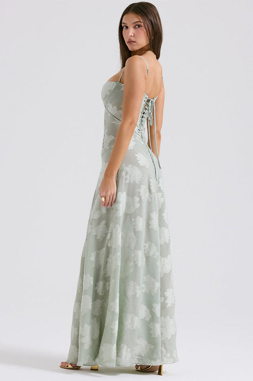 Three-quarter back view of women's sage green floral printed maxi dress with lace-up corset detail.