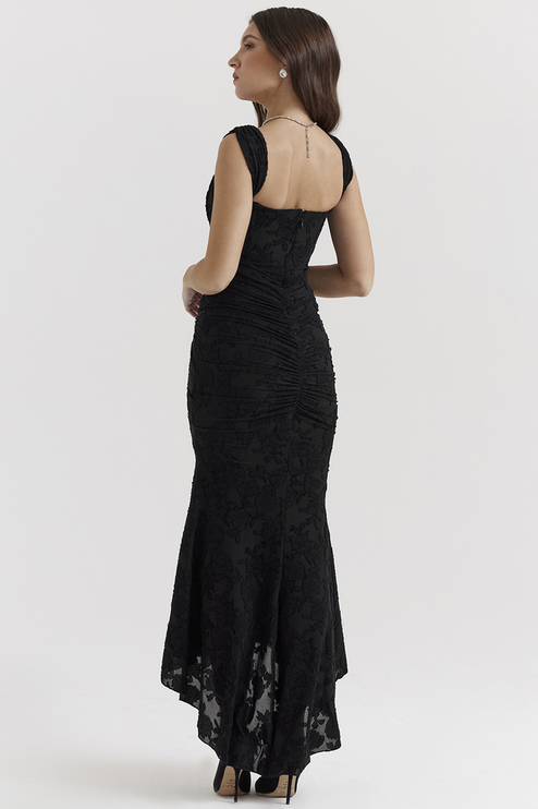 Back view of the black floral ruched off-shoulder maxi dress, showcasing the ruched detailing and elegant high-low hemline.