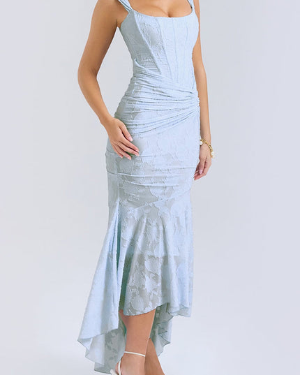 Side profile of the women's light blue floral ruched maxi dress, showing the elegant drape and high-low skirt with white heels.