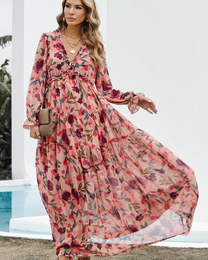 Women's flowing pink floral print maxi dress with long sleeves, ruffle details, and a V-neckline.