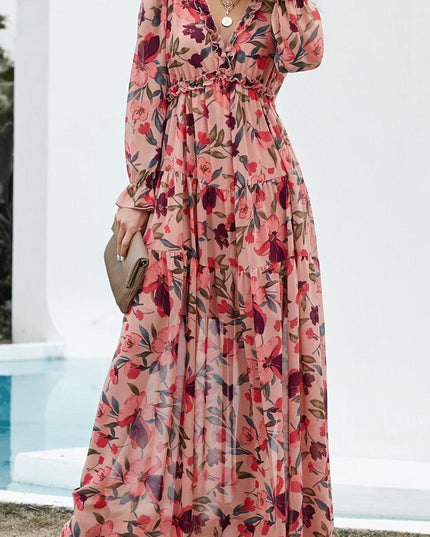 Full length view of a women's pink floral long sleeve maxi dress featuring ruffles and a V-neck.