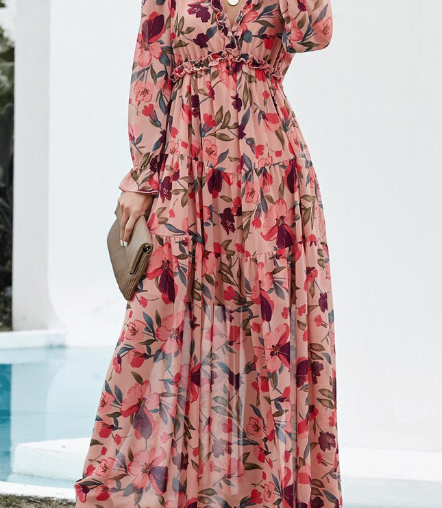 Full length view of a women's pink floral long sleeve maxi dress featuring ruffles and a V-neck.