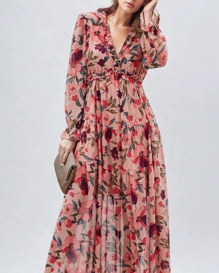 Women's pink floral long sleeve maxi dress with ruffles and a deep V-neck, holding a clutch.