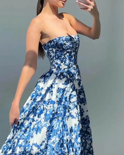 Women's strapless formal maxi dress with a vibrant blue and white floral pattern, featuring a fitted bodice and flowing skirt.