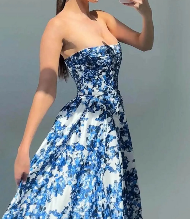 Women's strapless formal maxi dress with a vibrant blue and white floral pattern, featuring a fitted bodice and flowing skirt.