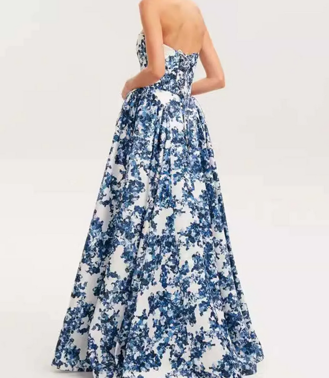 Back view of a women's blue and white floral strapless formal maxi dress, showing the full voluminous skirt and fitted back.
