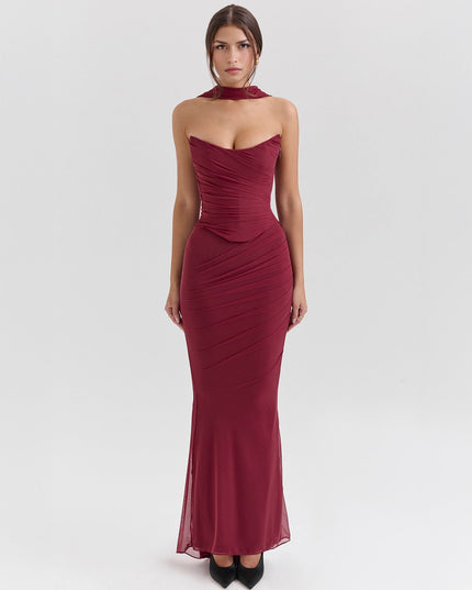Full-length view of a deep red strapless ruched maxi dress, with a matching choker and elegant, fitted design.