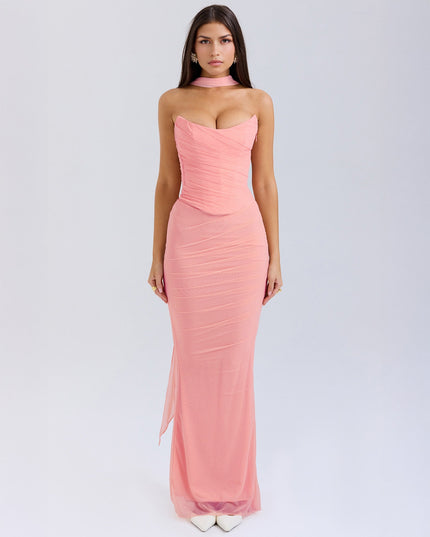 Full length view of a light pink strapless ruched maxi dress with a choker detail and sheer fabric overlay.