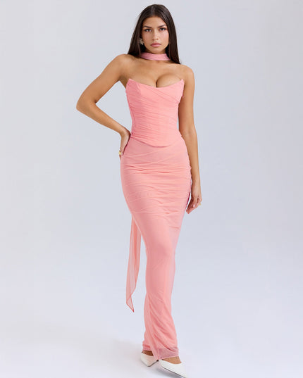Front view of the light pink strapless ruched maxi dress, showing the corset-style bodice and white heels.