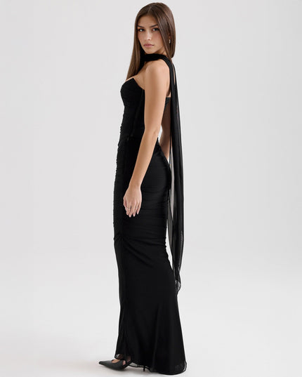 Side view of black strapless ruched maxi dress, showcasing the draped sheer fabric panel.
