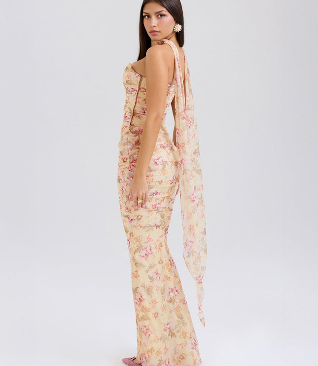 Back three-quarter view of the floral strapless ruched maxi dress, with a flowing sheer panel extending from the back.