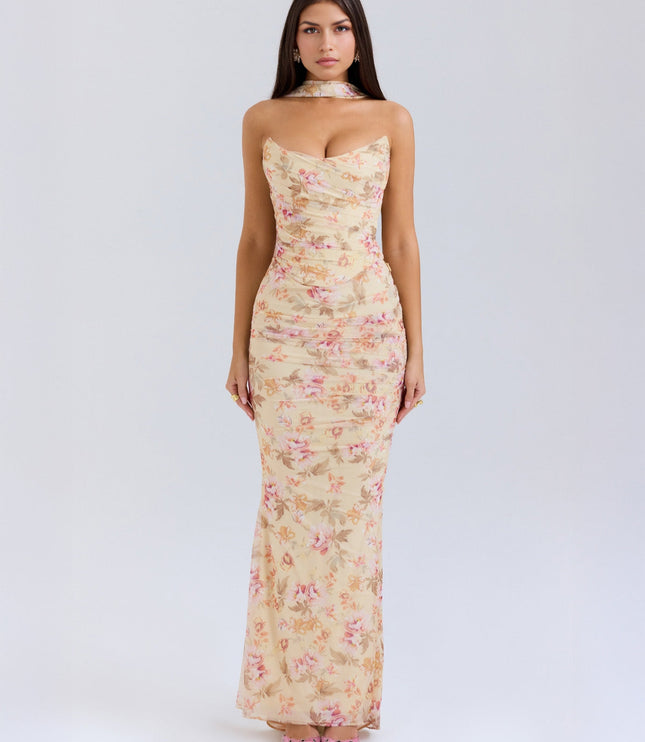 Full-length view of a women's floral strapless ruched maxi dress in light yellow with pink flowers, featuring a matching choker.