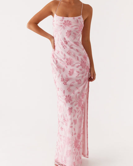 Front view of a light pink floral maxi dress with delicate beading and spaghetti straps, featuring a side slit.