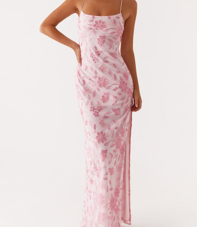 Front view of a light pink floral maxi dress with delicate beading and spaghetti straps, featuring a side slit.