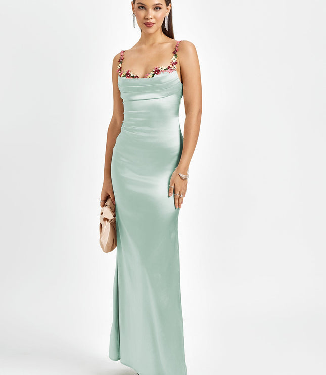 Elegant light mint green satin maxi dress with floral cowl neck, thin straps, and a small matching clutch.