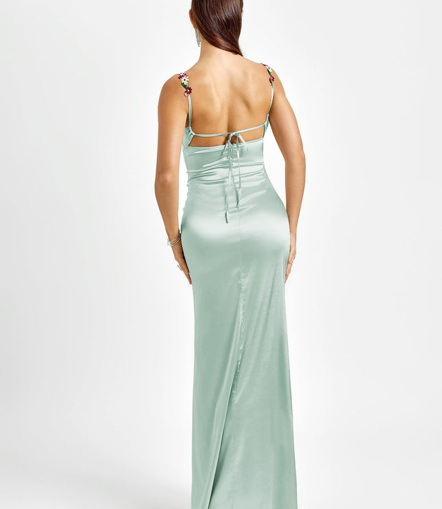 Back view of a light mint green formal maxi dress, highlighting the open back design with tie closures and floral straps.