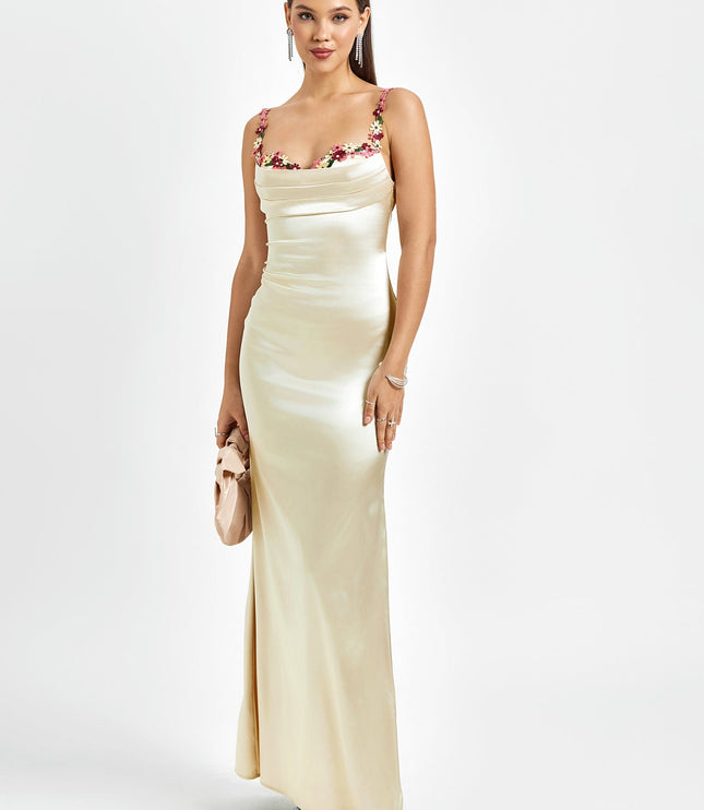 Elegant light champagne satin maxi dress with floral cowl neck and thin straps, paired with a small clutch.