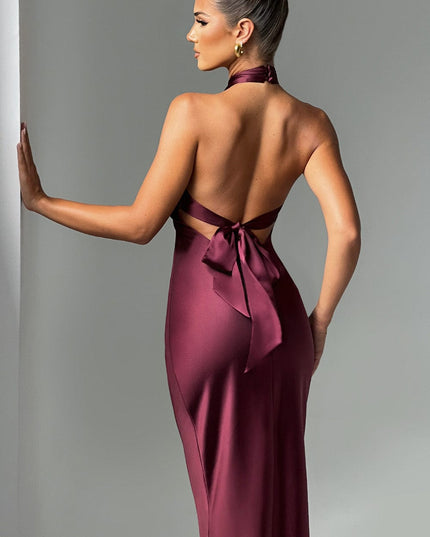 Back of women's burgundy formal dress, highlighting the open low back design and a tied bow detail at the waist.