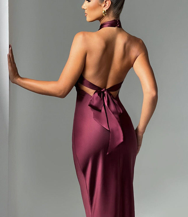 Back of women's burgundy formal dress, highlighting the open low back design and a tied bow detail at the waist.