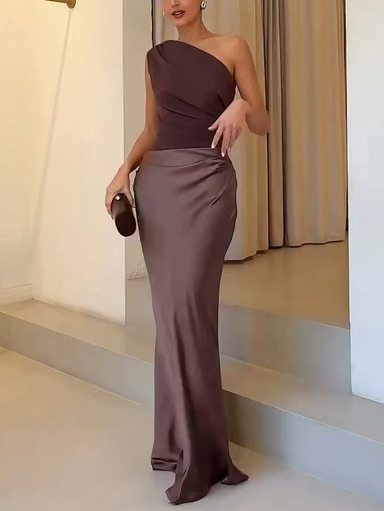 Close-up of the brown one-shoulder formal maxi dress, highlighting the gathered waist and flowing skirt fabric.